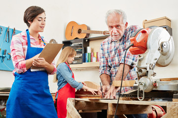 Frau macht Lehre im Handwerk bei Gitarrenbauer