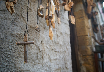 Simple wooden cross necklace with other accessories in the background