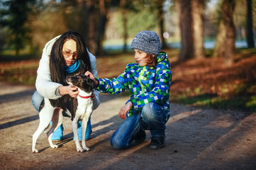 Obraz premium Mother and son walk their pet in the autumn Park.