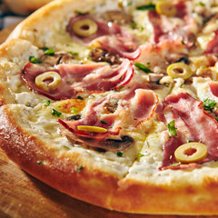Pizza Restaurant Menu - Delicious Fresh Pizza with Bacon and Olives. Pizza on Rustic Wooden Table with Ingredients