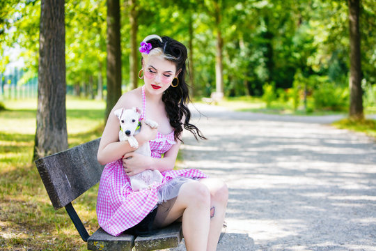 Portrait of a young Pin Up profile, holding a puppy in his arms