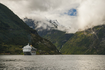 A cruiser in the Gejranger Fjord surrounded by high mountains in Norway © Pawel Sidlo