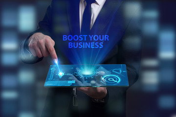 Business, Technology, Internet and network concept. Young businessman working on a virtual screen of the future and sees the inscription: Boost your business