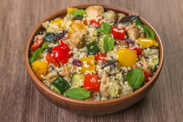 Tabbouleh salad with roasted vegetables, chicken and couscous. Close-up.