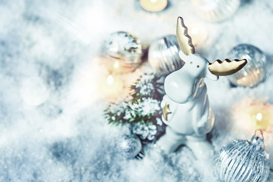 Adorable little white Christmas reindeer in snow