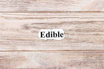 EDIBLE of the word on paper. concept. Words of EDIBLE on a wooden background