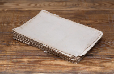 Old letter paper on a rustic wooden table, with blur background and space for copy.