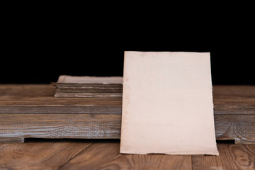 Old letter paper on a rustic wooden table, with blur background and space for copy.