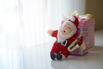 Santa and gift box by the window.