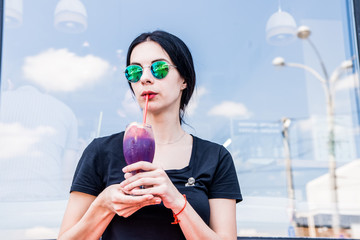 Woman drinks dark cocktail in outdoors restaurant © greentellect