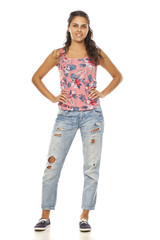 young woman with torn jeans standing on white background