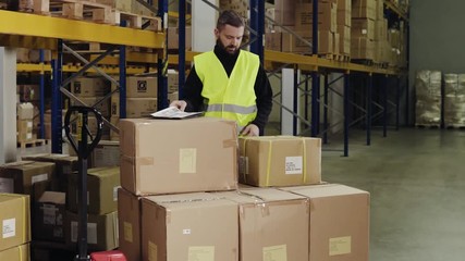 Male warehouse worker loading hand pallet truck. - Powered by Adobe