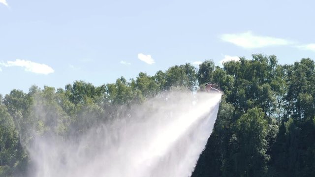 Man flies on flyboard and falls into the water through splashes