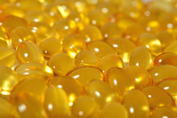 Omega-3 fish fat oil capsules as background texture.