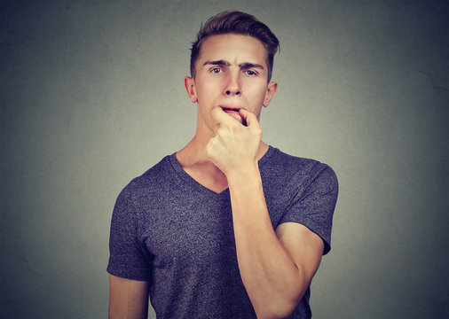 Young man trying to whistle isolated on gray wall background 