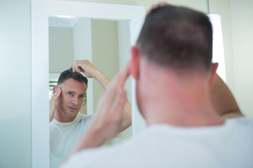Man combing his hair in bathroom