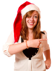Junge Frau mit Nikolausmütze zeigt mit dem Finger 