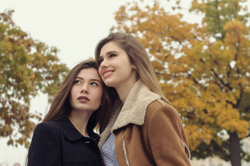 Close-up portrait of two girlfriends who touch their heads to each other