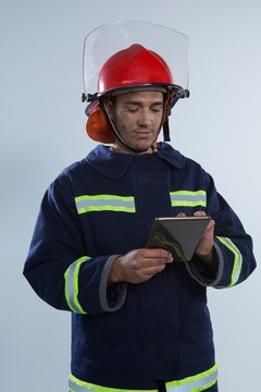 Fireman Using Digital Tablet Against White Background