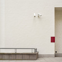 Two security cameras CCTV on the white stucco wall