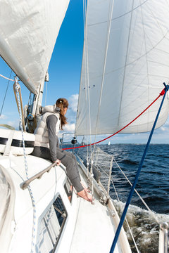 Young girl having trip on sailing yacht in windy sea