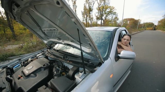 Sad woman in broken car