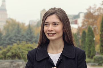Portrait of a beautiful girl who has fun walking along the street