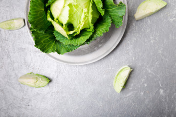 Fototapeta na wymiar Fresh green cabbage in metal plate on grey background. Top view. Copy space.