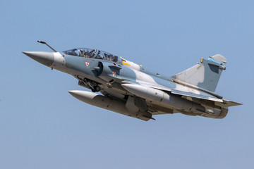 Blue camouflaged military fighter jet aircraft in flight