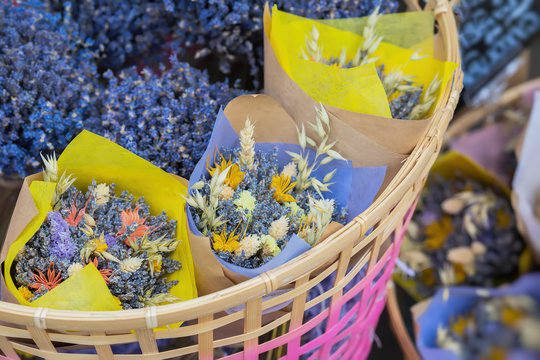 Close-up of creative bouquets of fresh lavender flowers in wicker basket, flower shop, studio. Delivery of flowers, smell plants, aroma