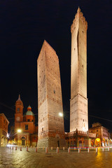 Two Towers, Asinelli and Garisenda, both of them leaning, symbol of Bologna, statue of San Petronius and Church of Saints Bartholomew and Gaetano at night, Bologna, Emilia-Romagna, Italy