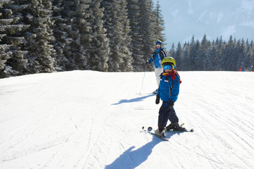 Fototapeta na wymiar Cute little boy, skiing happily in Austrian ski resort in the mountains
