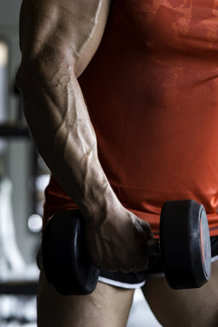 Close up of a dumbbell in hands of a professional powerlifter