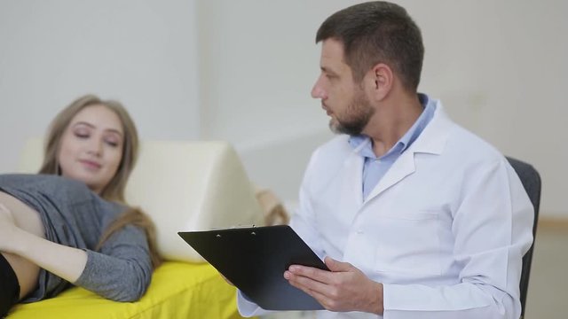 A doctor examines a pregnant woman and records the testimony in a medical record
