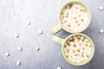 Two cup of hot coffee or chocolate with marshmallow on grey background. Flat lay marshmallow. Top view.