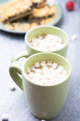 Two cup of hot coffee or chocolate and cake with marshmallow on grey background. Closeup.