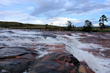 river flowing on red jasper in gran sabana