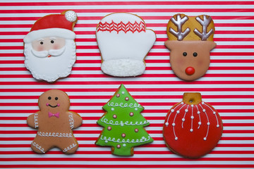 Christmas cookies on stripe background top view. Various types christmas gingerbread cookies flat lay. Christmas characters cookies. Christmas cookies background