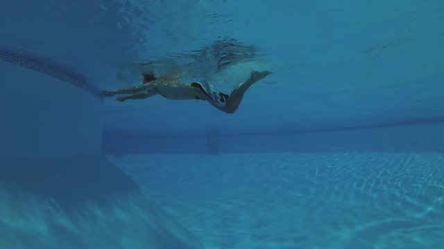 a man swim under water in the pool - underwater shot
