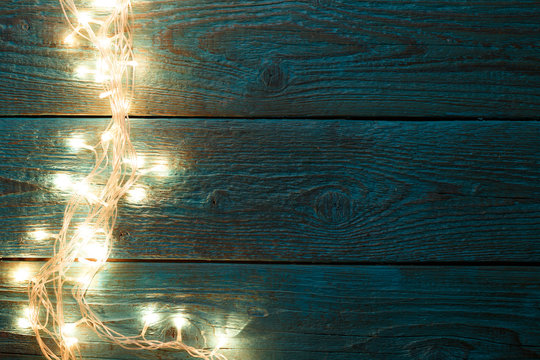 Image of blue wooden table with burning garland on side