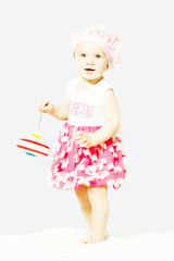 little girl is standing with toy whirligig