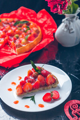 Strawberry pie on white plate black wooden table. One piece.  Romantic. Love. Heart. Toned photo. Valentine Day