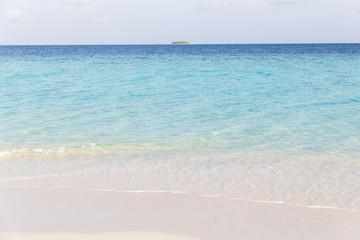 Fototapeta na wymiar clear ocean water with island in the distance