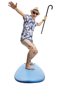 Joyful elderly tourist holding a cane and surfing
