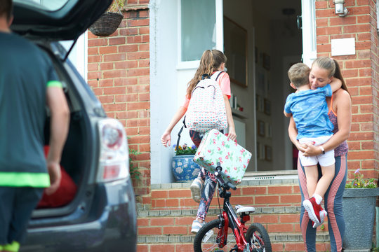 Family Unpacking Car After Holiday