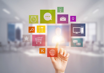 Modern office interior and close of businesswoman hand choosing icon on multimedia interface