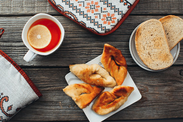 On wooden background, on the boards of toasted bread with tea and cakes