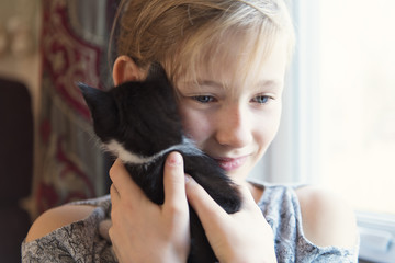 10 years old girl with kitten at home