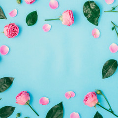 Round frame made of pink roses and green leaves