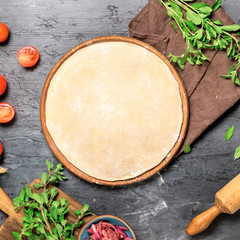 Raw pizza dough with set ingredients for cooking vegetarian pizza